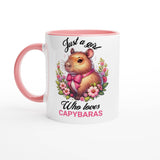 a pink and white coffee mug with a picture of a hamster